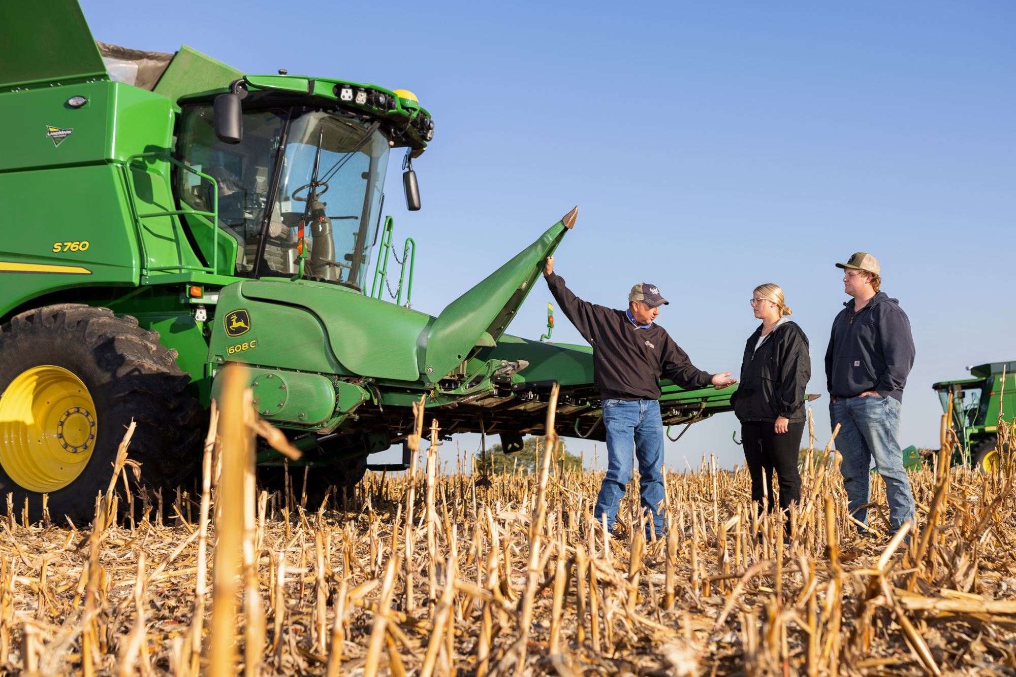 Instructor and students with combine in a field